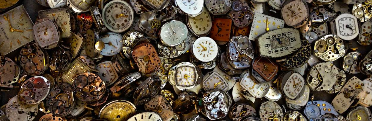 a pile of clocks showing the time