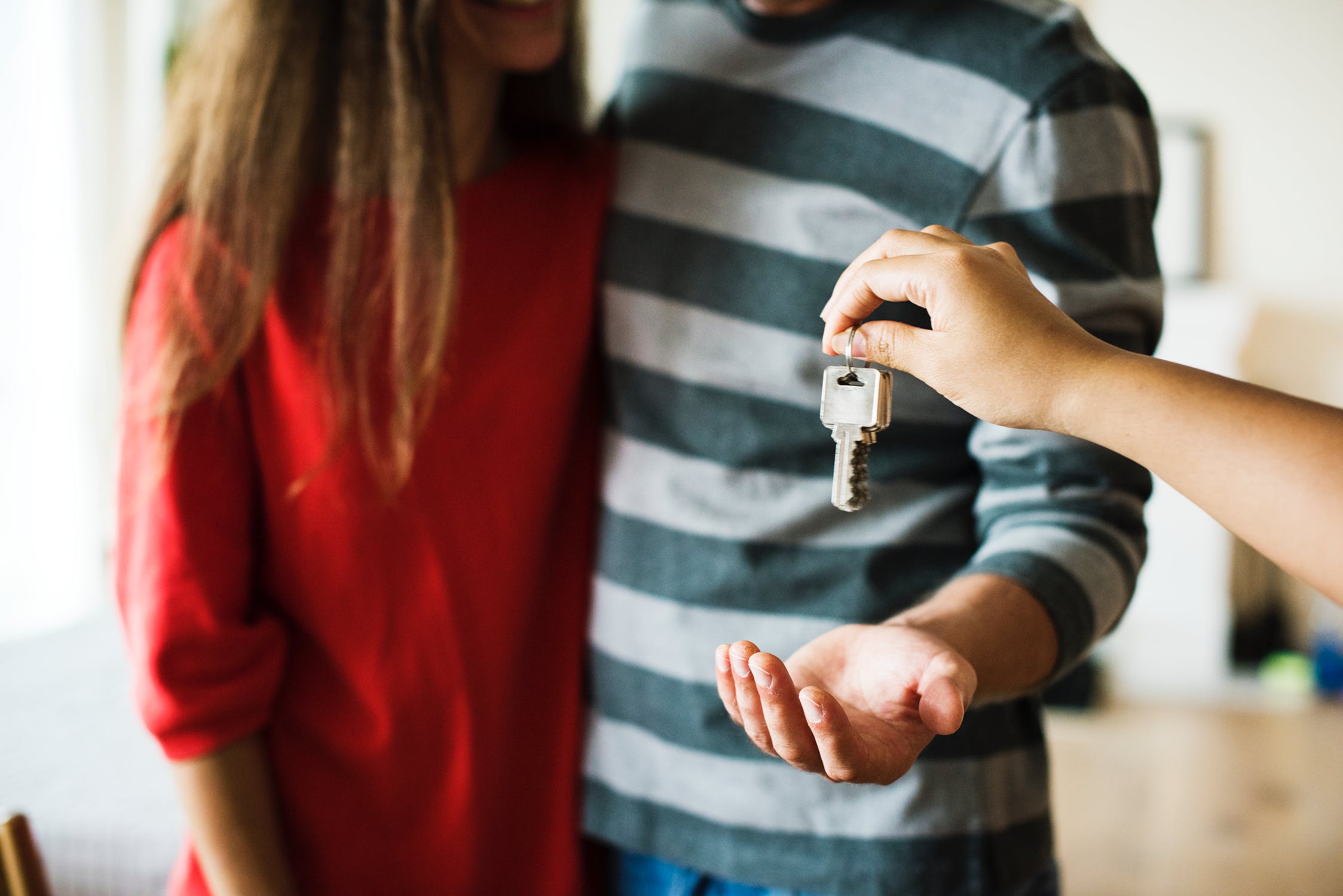 keys being handed to a couple who are buying a new house