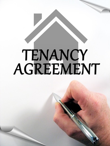 tenancy agreement document with someone holding a pen